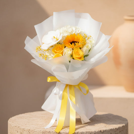 Hand-tied bouquet with sunflower, white orchid, hydrangea, yellow and white roses wrapped in elegant white paper