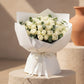 White rose bouquet with eucalyptus wrapped in elegant white paper and ribbon.