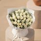 Top view of White Poise bouquet with fresh white roses arranged in soft white wrapping.