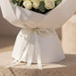 Close-up detail of white bouquet wrapping and ribbon on White Poise rose arrangement.