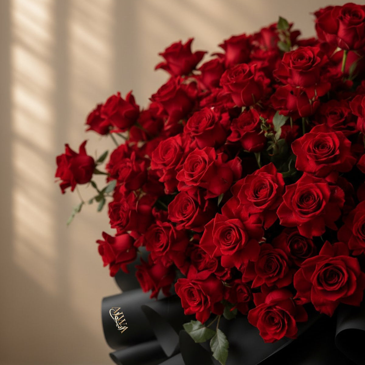 Close-up of lush red roses in a black wrapped bouquet by AIWA Flowers