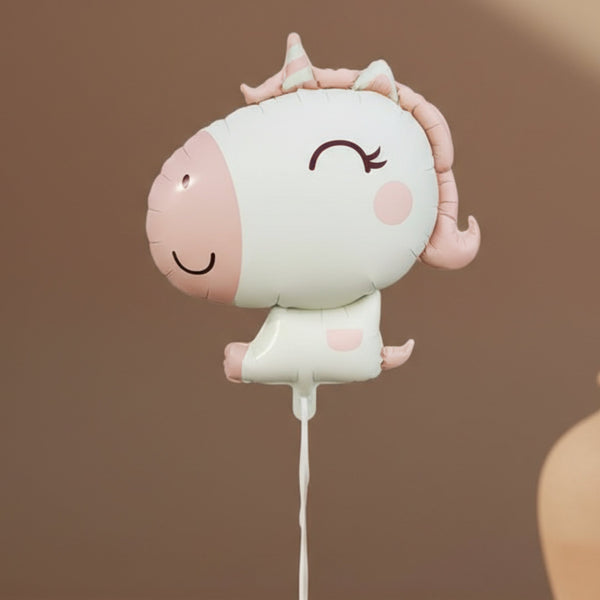 blush unicorn helium balloon held by model for birthday celebration