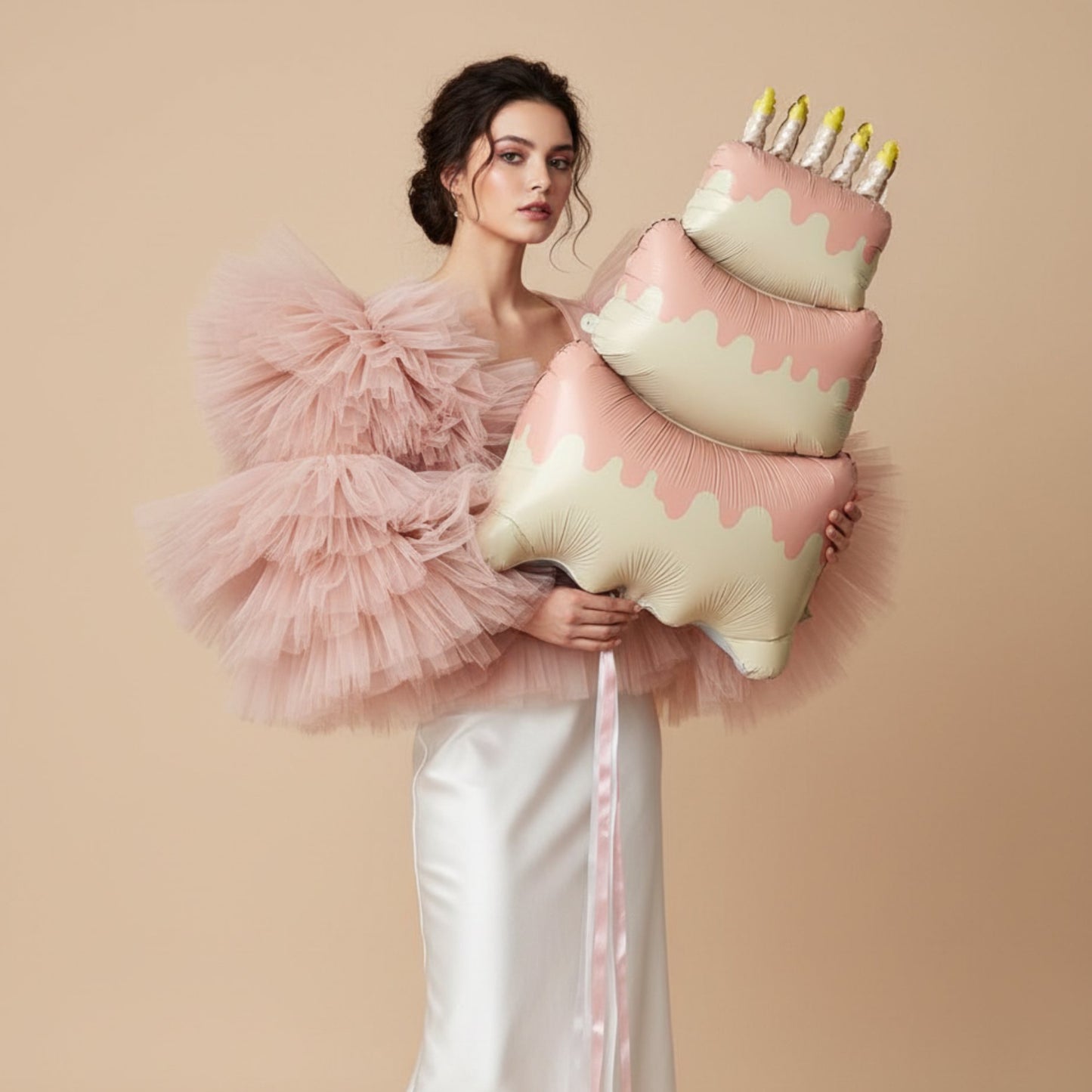 model holding large pink cake birthday helium balloon