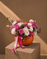 Candy Muncher Halloween arrangement of pink roses and white carnations in a fresh pumpkin with pink ribbons