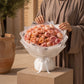 Woman holding a blush pink garden rose bouquet by AIWA Flowers Dubai