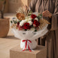 Woman holding a red rose bouquet with gold accents by AIWA Flowers Dubai