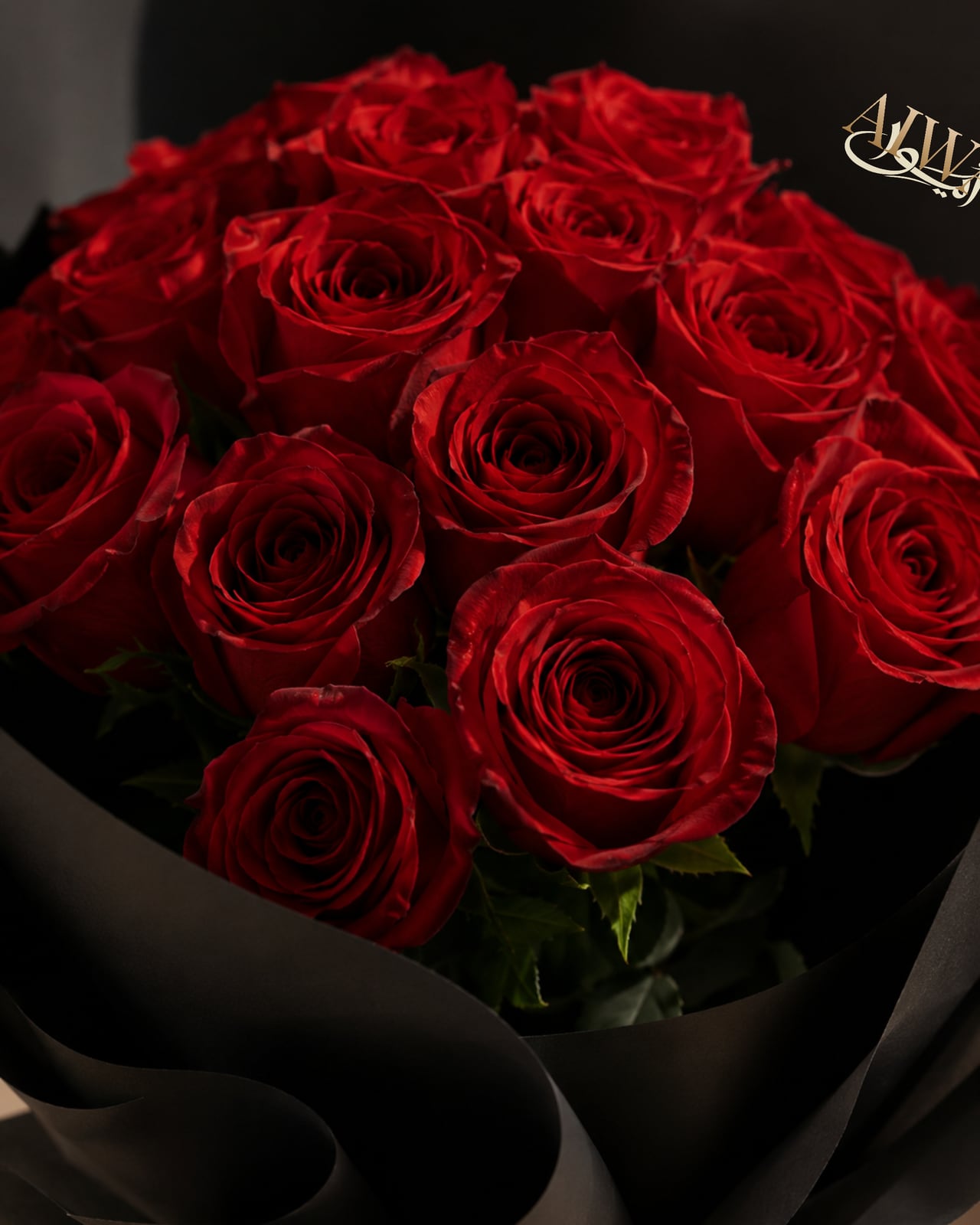 Close-up of red roses in black wrapping by AIWA Flowers Dubai
