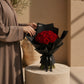 Woman holding a red rose bouquet in black wrap by AIWA Flowers Dubai