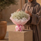 Woman holding a gypsophila baby's breath bouquet by AIWA Flowers Dubai