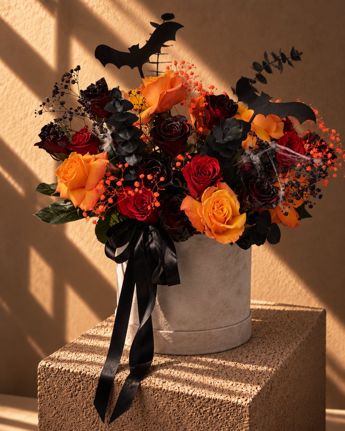 Creeper Halloween flower box of orange, red and black roses with bat toppers in a grey velvet box