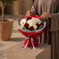 Woman holding a red and white rose bouquet with orchids by AIWA Flowers Dubai