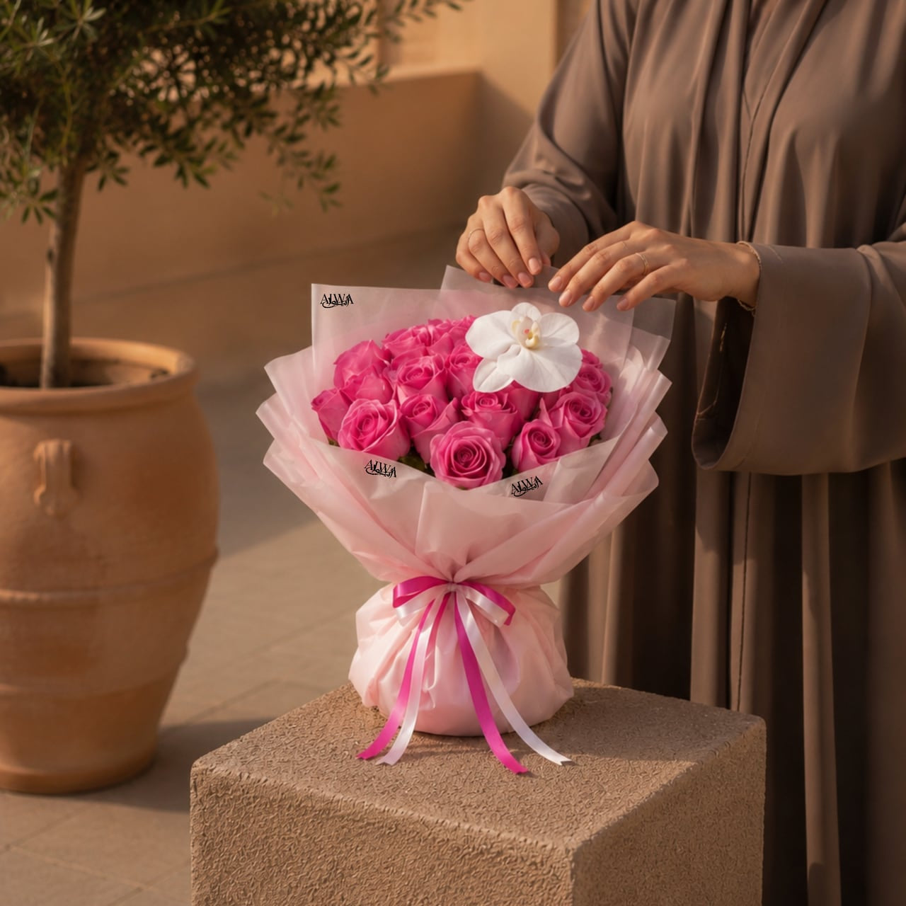 Woman holding a pink rose bouquet with white orchid by AIWA Flowers Dubai
