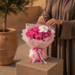 Woman holding a pink rose bouquet with white orchid by AIWA Flowers Dubai