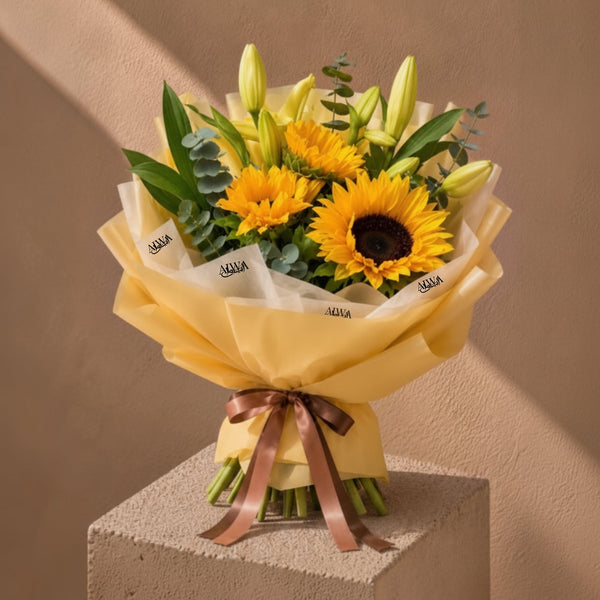 Sunflower and lily bouquet in gold wrap by AIWA Flowers Dubai