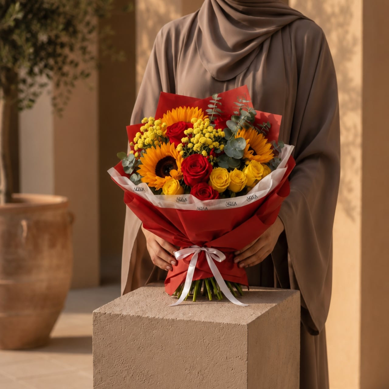Woman holding a sunflower and rose bouquet by AIWA Flowers Dubai