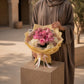 Woman holding a pink rose and hydrangea bouquet by AIWA Flowers Dubai