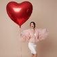 model holding giant red heart helium balloon