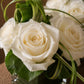 Close-up of pristine white roses with green leaves in a clear glass cube - Grace by AIWA Flowers