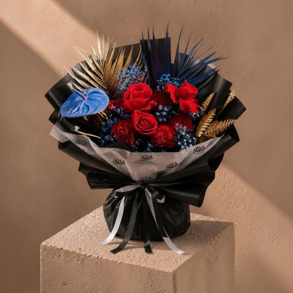Red rose and blue anthurium bouquet in black wrap by AIWA Flowers Dubai