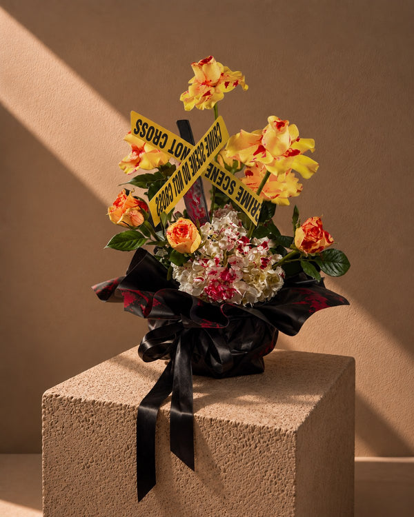 Haunted Harvest Halloween arrangement of yellow and orange roses with crime scene tape in black wrapping