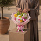 Woman holding a pink and yellow rose bouquet with heart accent by AIWA Flowers Dubai