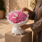 Woman holding a pink rose bouquet with butterfly accent by AIWA Flowers Dubai