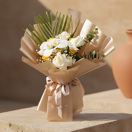 Honey hand-tied bouquet with white orchids, white and yellow roses, gypsophila and eucalyptus in gold wrapping by Aiwa Flowers