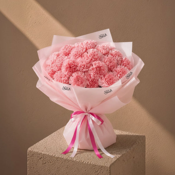 Pink carnation bouquet in soft pink wrap by AIWA Flowers Dubai