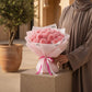 Woman holding a pink carnation bouquet by AIWA Flowers Dubai