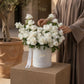 Woman arranging white spray roses in a box by AIWA Flowers Dubai