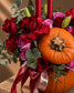 Close-up of red roses, lilac roses and a mini pumpkin topper in the Jack arrangement
