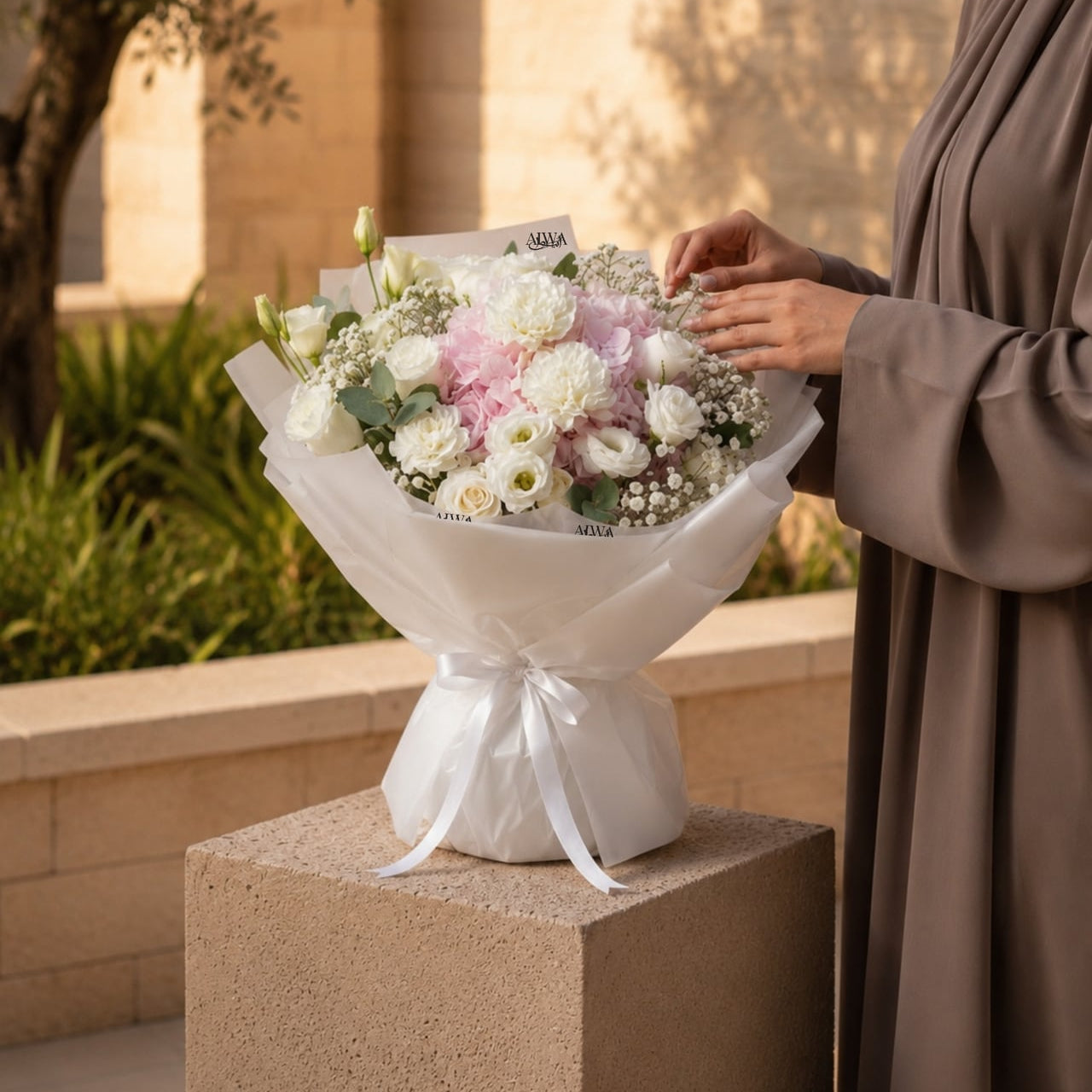 Woman holding a white and pink hydrangea bouquet by AIWA Flowers Dubai