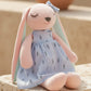 Close-up of pastel bunny plush toy with embroidered face and blue dress, soft gift idea