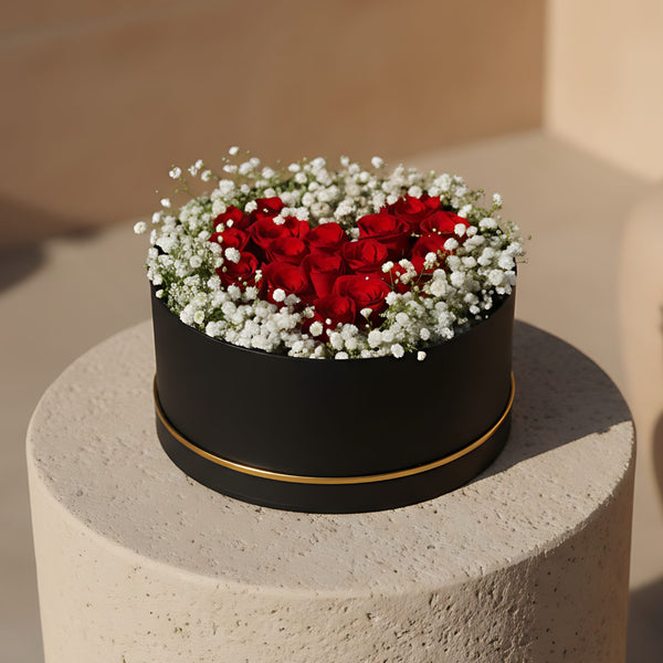 Lovely Cloud black flower box with red roses and gypsophila arranged in a heart shape
