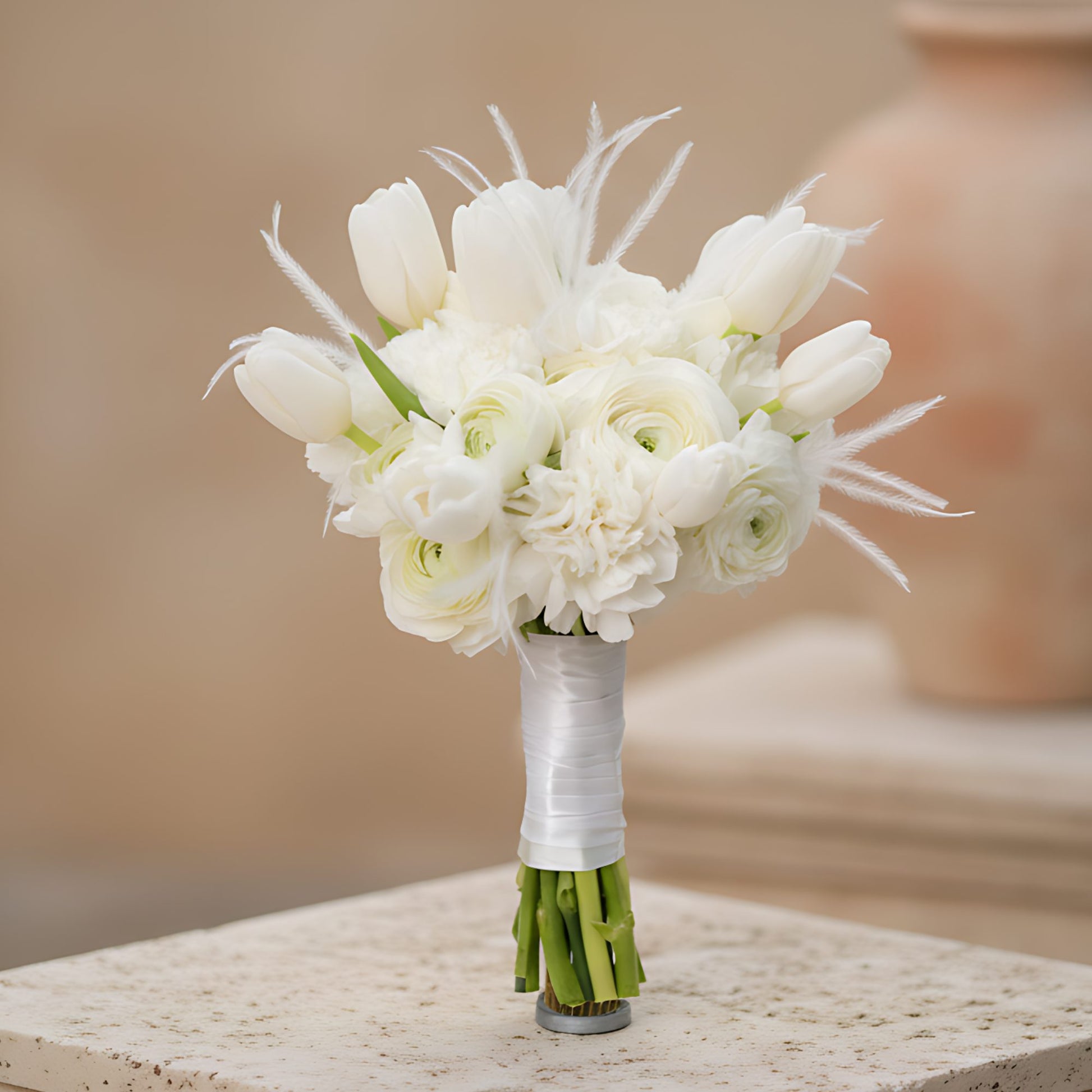 Lullaby bridal bouquet with white ranunculus, carnations, tulips and feather accents by Aiwa Flowers