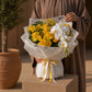 Woman holding a warm yellow rose and orchid bouquet in white wrap - Mellow Yellow by AIWA Flowers