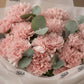 Close-up of blush pink carnations with silver eucalyptus by AIWA Flowers