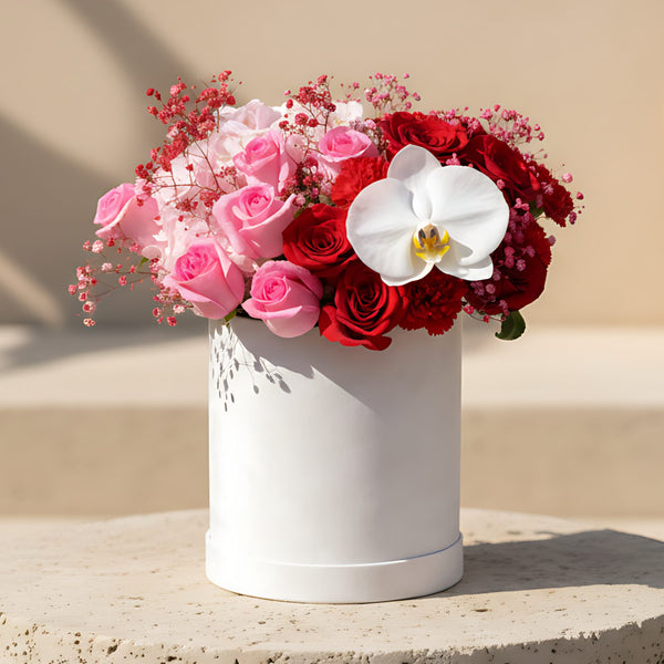 Mozart flower box with pink and red roses, red carnations, orchid and hydrangea in a white velvet box