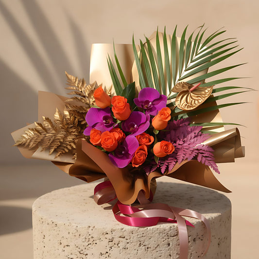 Neon hand-crafted bouquet with orange roses, purple orchids and gold accents in gold wrapping