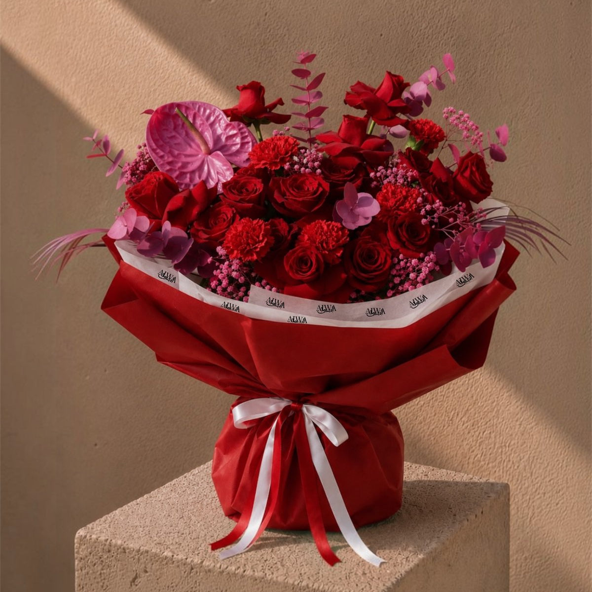 Red roses and carnations with a pink anthurium in red wrapping - Noctelle by AIWA Flowers