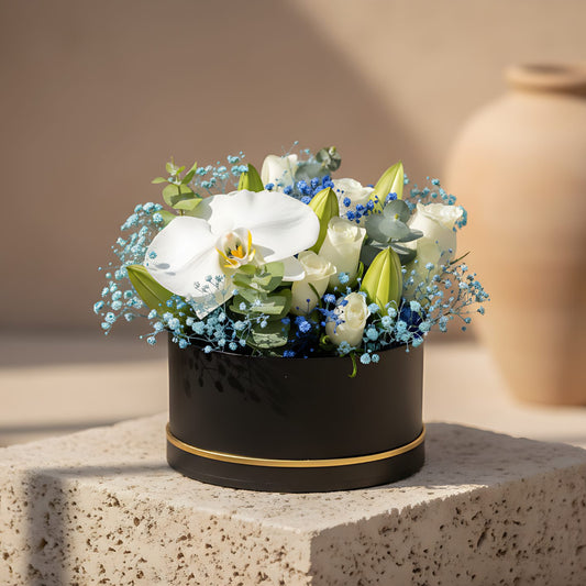 Ocean flower box with white roses, lilies, orchid, blue gypsophila and eucalyptus in a black round box