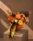 Omen Halloween arrangement of orange and yellow roses in a fresh pumpkin with gold and black ribbons