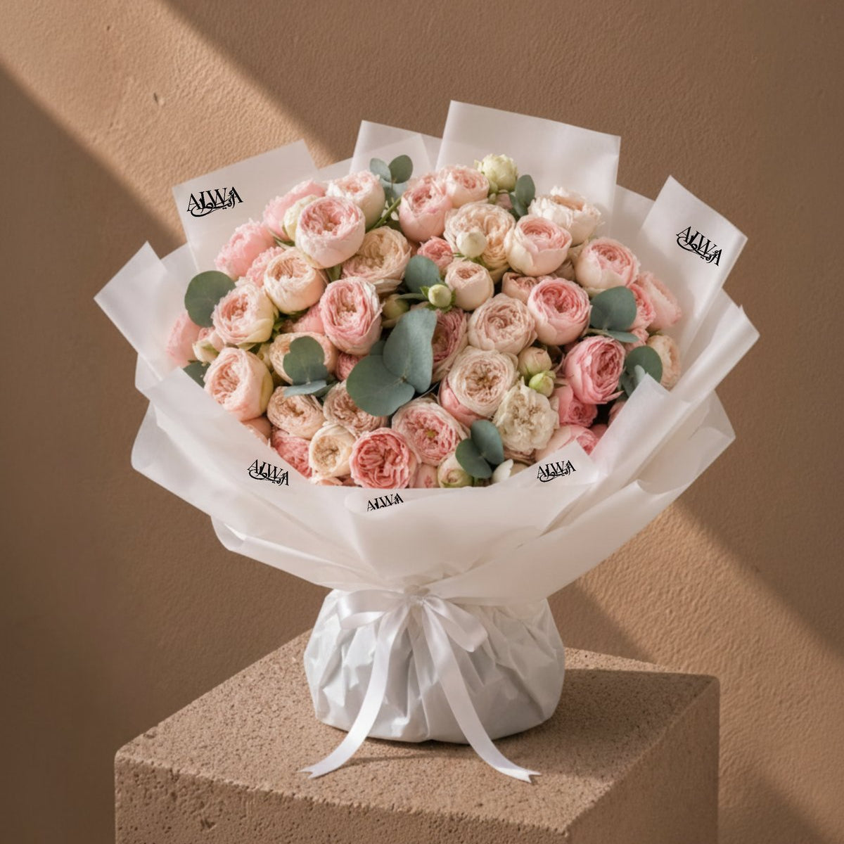 Grand blush and cream garden-rose bouquet with eucalyptus in white wrap by AIWA Flowers