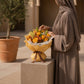 Woman with a sunny yellow rose and orange bouquet in yellow wrap - Papaya by AIWA Flowers