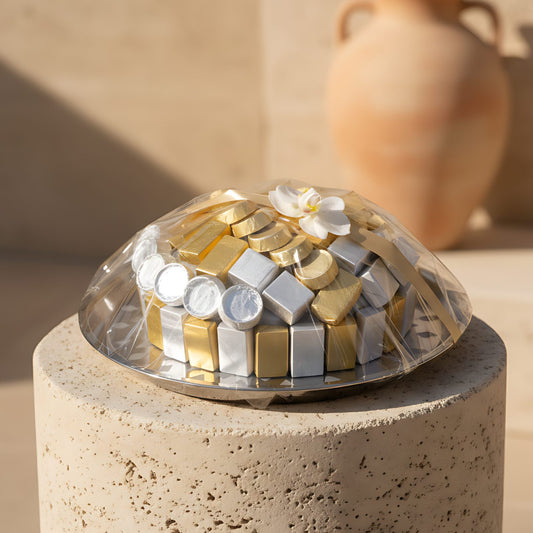 Pearl of Faith gourmet chocolates with a white orchid presented on a silver tray