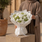 Woman holding a white carnation and green hydrangea bouquet in white wrap - Pearl by AIWA Flowers