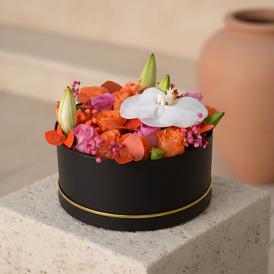 Popsicle black flower box with orange and pink roses, lilies, orchid and gypsophila
