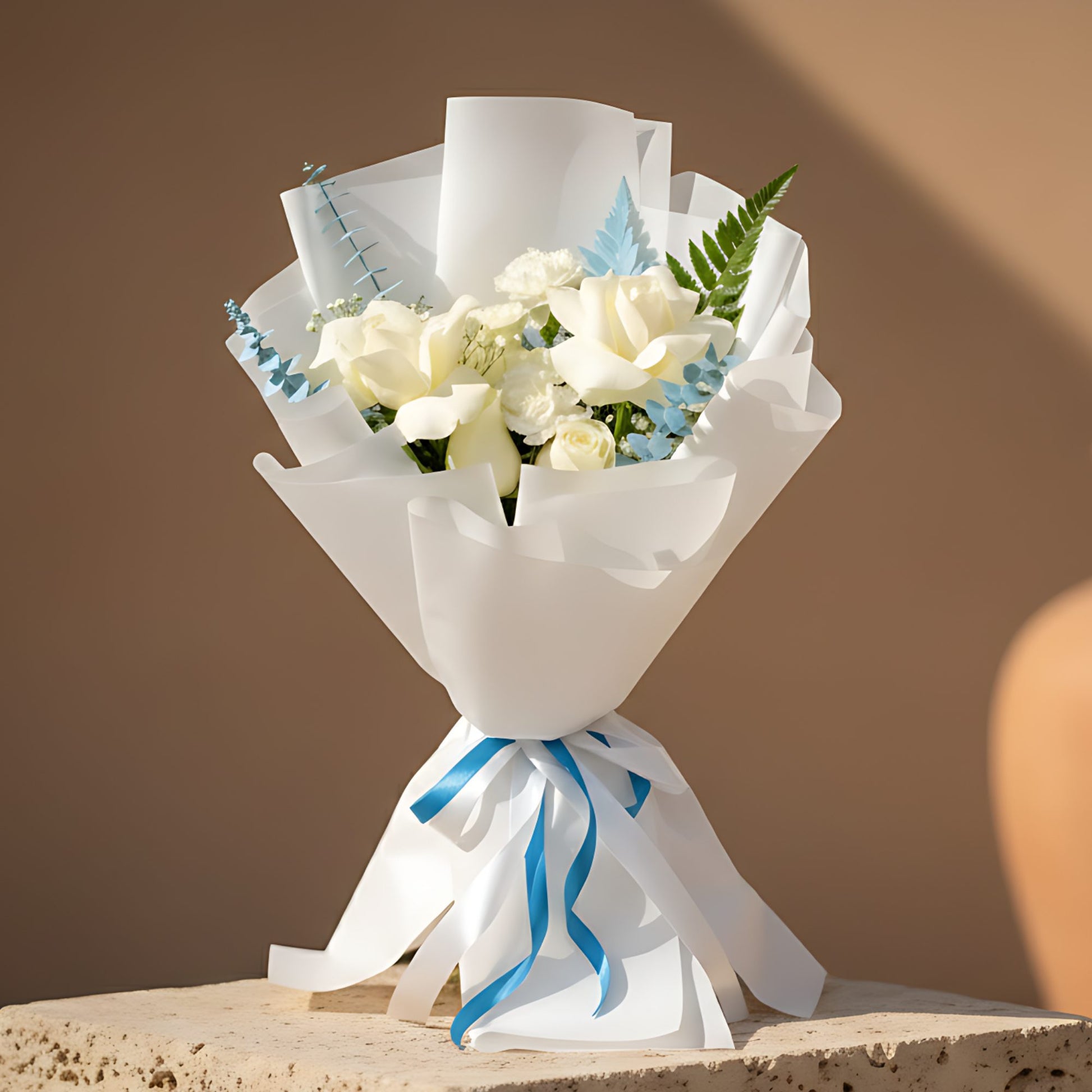 Prince hand-tied bouquet with white roses, white carnations, gypsophila, blue eucalyptus and fern in white wrapping by Aiwa Flowers