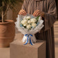 Woman holding a white rose and carnation bouquet with blue eucalyptus - Prince by AIWA Flowers