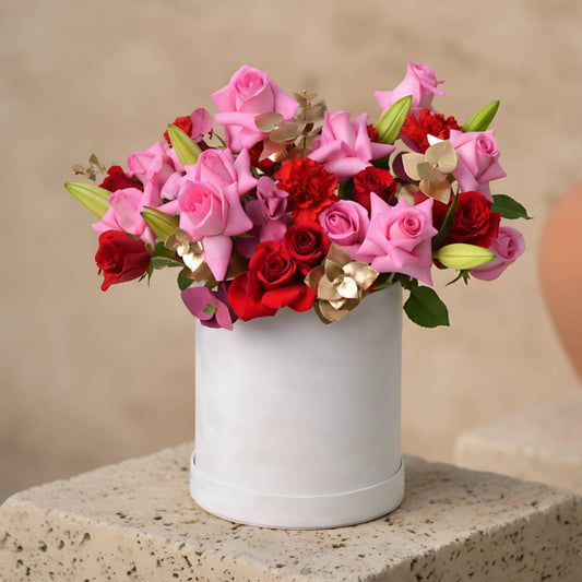 Quartz Pink flower box with pink and red roses, lilies, red carnations and eucalyptus in a white velvet box